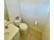 A simple bathroom with a toilet, paper holder, neutral tile, and a white vanity at 312 Partridge Pea Ln, Ocoee, FL 34761