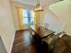 Bright dining room featuring hardwood floors, a modern light fixture, and large windows with yellow curtains at 312 Partridge Pea Ln, Ocoee, FL 34761