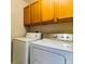 Efficient laundry area with front-load washer and dryer, complemented by upper cabinets for storage at 312 Partridge Pea Ln, Ocoee, FL 34761