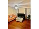 Cozy living room with hardwood floors, peach couch, modern white table, and ceiling fan at 312 Partridge Pea Ln, Ocoee, FL 34761