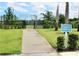 Scenic school walkway surrounded by lush greenery, leading to a fenced sports area for outdoor activities at 312 Partridge Pea Ln, Ocoee, FL 34761