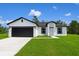 Charming single-story home boasts a black-on-white color scheme and neatly manicured lawn at 313 Bass Ct, Kissimmee, FL 34759