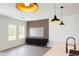 Open concept staged living room with modern accent wall, cabinet, and pendant lighting at 313 Bass Ct, Kissimmee, FL 34759
