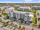 Aerial view of a modern apartment building with ample parking and beautifully landscaped grounds in a vibrant community setting at 3180 Paradox Cir # 304, Kissimmee, FL 34746