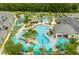 Aerial view of a community pool area with multiple pools, a lazy river, cabanas, and lush landscaping, perfect for relaxation at 3180 Paradox Cir # 304, Kissimmee, FL 34746