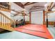 This finished basement includes fitness equipment, a wrestling mat, high ceilings, and exposed wood beams at 3461 Michigan St, Lake Mary, FL 32746