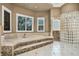 Elegant primary bath with soaking tub, glass block shower, and shuttered windows at 3461 Michigan St, Lake Mary, FL 32746
