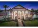 Elegant exterior showcasing grand architecture, lush landscaping, and a pathway leading to the entrance at 3461 Michigan St, Lake Mary, FL 32746