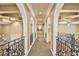 View of an elegant hallway with arches, ornate railings, and a neutral color palette at 3461 Michigan St, Lake Mary, FL 32746
