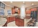 This kitchen has cherry cabinets, dark countertops, and a kitchen island with seating at 3461 Michigan St, Lake Mary, FL 32746