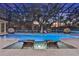 Inviting pool with in-water loungers and serene views, surrounded by a screened enclosure and lush landscaping at 3461 Michigan St, Lake Mary, FL 32746
