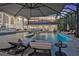 Luxurious outdoor pool area with comfortable lounge chairs and an umbrella, ideal for relaxing and enjoying the serene surroundings at 3461 Michigan St, Lake Mary, FL 32746