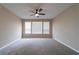 Spacious carpeted bedroom with neutral walls and a ceiling fan, illuminated by natural light from three large windows at 3651 Nw 56Th Ave, Ocala, FL 34482
