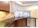 Kitchen with stainless steel dishwasher, granite countertops and bar, and cherry cabinets at 3651 Nw 56Th Ave, Ocala, FL 34482
