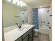 Modern bathroom featuring a large mirror, vanity, gray cabinets and a shower with curtain at 4007 Meandering Bay Dr, Apopka, FL 32712