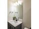 Stylish powder room with a dark vanity, quartz countertop, and modern lighting fixture at 4007 Meandering Bay Dr, Apopka, FL 32712