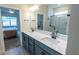 Bathroom featuring double sink vanity, large mirror and glass enclosed shower at 4007 Meandering Bay Dr, Apopka, FL 32712