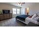 Well-lit bedroom featuring a ceiling fan, large windows, and a wood dresser with a television at 4007 Meandering Bay Dr, Apopka, FL 32712