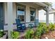 Relax on the cozy front porch featuring comfortable blue rocking chairs and charming views at 4007 Meandering Bay Dr, Apopka, FL 32712