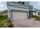 View of the two-car garage and brick paver driveway of this charming two-story home at 4007 Meandering Bay Dr, Apopka, FL 32712