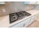 Close up of gas range cooktop with five burners, stainless steel knobs, and white quartz countertops at 4007 Meandering Bay Dr, Apopka, FL 32712