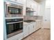 Modern kitchen with stainless steel appliances, white cabinets, gas range cooktop and modern oven at 4007 Meandering Bay Dr, Apopka, FL 32712