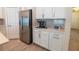 Coffee bar area with stainless steel refrigerator, white cabinets and drawers with dark subway tile backsplash at 4007 Meandering Bay Dr, Apopka, FL 32712