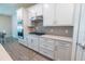 Gourmet kitchen features white cabinets, stainless steel appliances, and a gas range cooktop with a modern backsplash at 4007 Meandering Bay Dr, Apopka, FL 32712