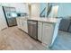 Kitchen island with stainless steel dishwasher, white cabinets and drawers with hardware and wood-style flooring at 4007 Meandering Bay Dr, Apopka, FL 32712