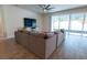 Bright living room with a large sectional sofa, ceiling fan, and sliding glass doors leading to the outdoor patio at 4007 Meandering Bay Dr, Apopka, FL 32712