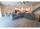 Open concept living room featuring a large couch, kitchen and dining area and stairway at 4007 Meandering Bay Dr, Apopka, FL 32712