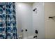 Close up of white tiled shower with blue patterned shower curtain at 4007 Meandering Bay Dr, Apopka, FL 32712
