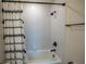 White tiled shower featuring a white shower curtain with black tassels at 4007 Meandering Bay Dr, Apopka, FL 32712