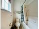 Standard bathroom with shower/tub, standard toilet, and a window providing natural light at 4900 Beach Blvd, Orlando, FL 32803