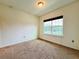 A cozy bedroom with neutral carpet and a large window at 4900 Beach Blvd, Orlando, FL 32803