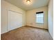 Bright bedroom featuring a large window and a closet with folding doors, carpeted floors and neutral walls at 4900 Beach Blvd, Orlando, FL 32803