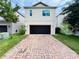 Modern two-story home with a dark garage door and a brick-paved driveway at 4900 Beach Blvd, Orlando, FL 32803