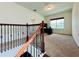 Upstairs carpeted hallway with dark wrought iron banister leading to a home office at 4900 Beach Blvd, Orlando, FL 32803