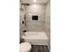 Bathroom with gray tiled walls, a bathtub, rainfall shower head and black hardware at 5118 Log Wagon Rd, Ocoee, FL 34761
