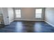 Spacious bedroom with dark vinyl flooring and two windows offering ample natural light at 5118 Log Wagon Rd, Ocoee, FL 34761