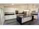 Bright kitchen boasts white cabinets, black countertops, stainless appliances, and a large island at 5118 Log Wagon Rd, Ocoee, FL 34761
