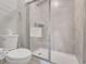 Bright bathroom featuring a tile surround shower with a glass door and white fixtures at 720 Gardenia Ln, Davenport, FL 33897