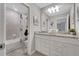 Well-lit bathroom with double vanity, granite countertops, and tiled shower/tub at 720 Gardenia Ln, Davenport, FL 33897