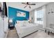 Bright bedroom featuring a king bed, striking blue accent wall and ceiling fan at 720 Gardenia Ln, Davenport, FL 33897