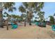 Hammock area with sand, chairs, and many palm trees providing a great space for relaxation at 720 Gardenia Ln, Davenport, FL 33897