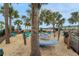 Hammock area with sand, chairs, and many palm trees providing a great space for relaxation at 720 Gardenia Ln, Davenport, FL 33897