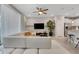 Open-concept living room with a white sectional sofa, ceiling fan, and adjacent modern kitchen at 720 Gardenia Ln, Davenport, FL 33897