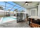 Screened in pool with patio furniture, ceiling fan, and safety fence offers a tranquil retreat at 720 Gardenia Ln, Davenport, FL 33897