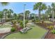A vibrant putting green is beautifully landscaped with rocks, plants and trees at 720 Gardenia Ln, Davenport, FL 33897