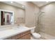 Bright bathroom featuring tile shower, modern vanity with large mirror, and unique wall decor at 7461 Bleecker Ln, Kissimmee, FL 34747